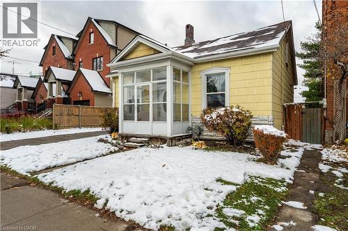 Snow covered property featuring a chimney and a sunroom - 193 Locke Street N, Hamilton, ON - Outdoor