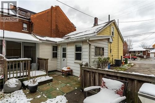 Snow covered rear of property featuring a chimney and a wooden deck - 193 Locke Street N, Hamilton, ON - Outdoor