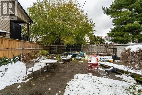 Snow covered patio with a patio and a fenced backyard - 193 Locke Street N, Hamilton, ON - Outdoor With Backyard