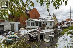 Snow covered back of property featuring a patio area and a sunroom - 