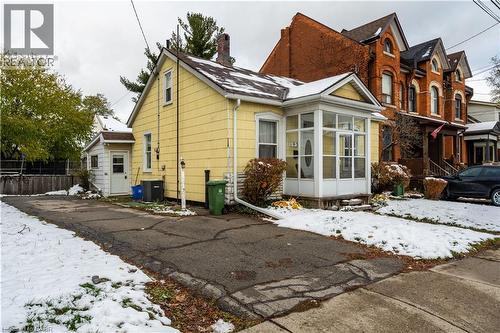 View of snowy exterior with a chimney and a sunroom - 193 Locke Street N, Hamilton, ON - Outdoor