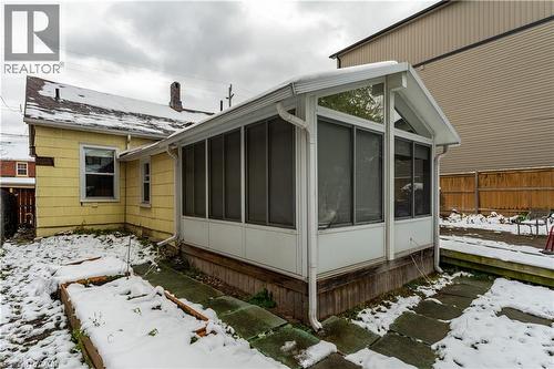 View of snow covered exterior featuring a sunroom - 193 Locke Street N, Hamilton, ON - Outdoor With Exterior