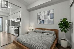 Bedroom featuring dark wood-style floors and freestanding refrigerator - 