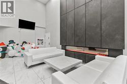 Living room featuring a high ceiling and light marble finish flooring - 