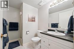 Full bath with a shower stall, vanity, and light tile patterned floors - 
