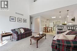 Living area featuring light carpet and a towering ceiling - 