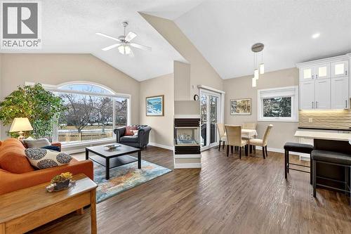 OPEN CONCEPT living, dining and kitchen with 3-sided gas fireplace - 509 Riverview Place Se, Calgary, AB - Indoor Photo Showing Living Room