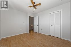 Unfurnished bedroom with light wood finished floors, ceiling fan, and a closet - 