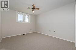 Spare room featuring carpet and a ceiling fan - 