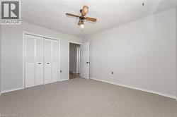 Unfurnished bedroom featuring a closet, carpet floors, a ceiling fan, and a textured ceiling - 
