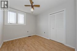 Unfurnished bedroom with light wood-type flooring, a ceiling fan, and a closet - 