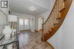 Tiled entrance foyer with french doors, arched walkways, healthy amount of natural light, and stairs - 