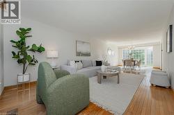 Living room featuring light wood-style floors and a chandelier - 