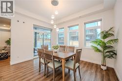 Dining room with a raised ceiling, healthy amount of natural light, and wood finished floors - 