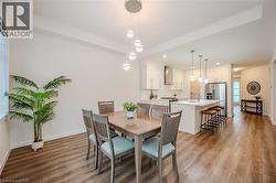 Dining room featuring light wood-type flooring, recessed lighting, and a raised ceiling - 