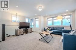 Living area with light carpet, recessed lighting, and healthy amount of natural light - 