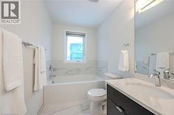 Bathroom featuring vanity, a garden tub, and light marble finish floors - 