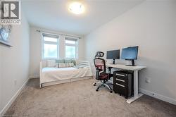 Bedroom featuring light carpet and a desk - 