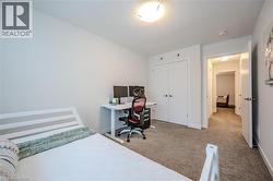 Bedroom featuring light carpet, a desk, a closet, and a textured ceiling - 
