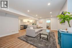 Living room with recessed lighting and light wood-type flooring - 