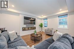 Living area featuring a raised ceiling, wood finished floors, and recessed lighting - 