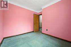 Carpeted spare room featuring baseboards - 