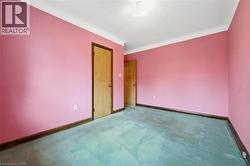 Carpeted empty room featuring baseboards - 