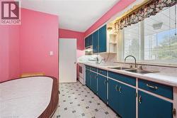 Kitchen featuring blue cabinetry, light floors, light countertops, electric stove, and open shelves - 