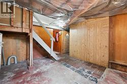 Unfinished below grade area featuring wood walls and stairs - 