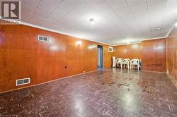 Finished basement with wood walls, ornamental molding, and tile patterned floors - 