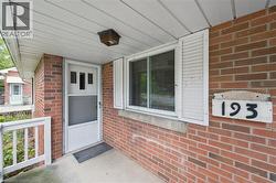 Doorway to property featuring brick siding and a porch - 