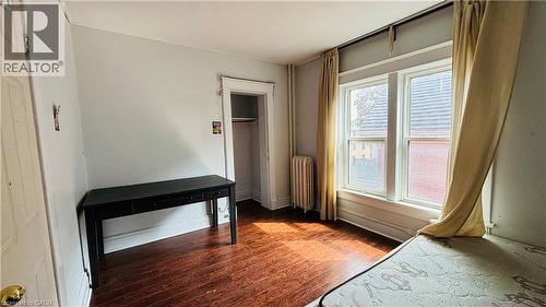 Unfurnished bedroom featuring dark wood finished floors and radiator heating unit - 30 Regina Street N, Waterloo, ON - Indoor Photo Showing Other Room