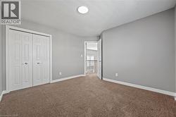 Unfurnished bedroom with a closet, baseboards, and carpet flooring - 