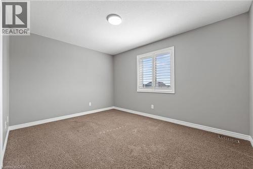 Empty room with carpet flooring, baseboards, visible vents, and a textured ceiling - 561 Thomas Slee Drive, Kitchener, ON - Indoor Photo Showing Other Room
