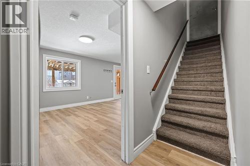 Staircase with wood finished floors, baseboards, and a textured ceiling - 561 Thomas Slee Drive, Kitchener, ON - Indoor Photo Showing Other Room