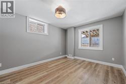 Empty room with light wood finished floors, a textured ceiling, and baseboards - 