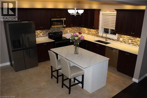 Kitchen with black appliances, backsplash, and dark brown cabinets - 561 Thomas Slee Drive, Kitchener, ON - Indoor Photo Showing Kitchen With Double Sink
