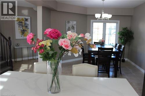 Dining room with light tile patterned flooring, a chandelier, and stairs - 561 Thomas Slee Drive, Kitchener, ON - Indoor Photo Showing Dining Room