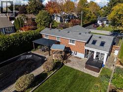 Rear view of property featuring a hot tub, brick siding, a residential view, a chimney, and roof with shingles - 