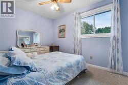 Carpeted bedroom with baseboards and a ceiling fan - 