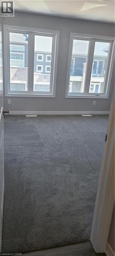 Empty room with dark carpet and baseboards - 17 Renfrew Trail, Welland, ON - Indoor Photo Showing Other Room