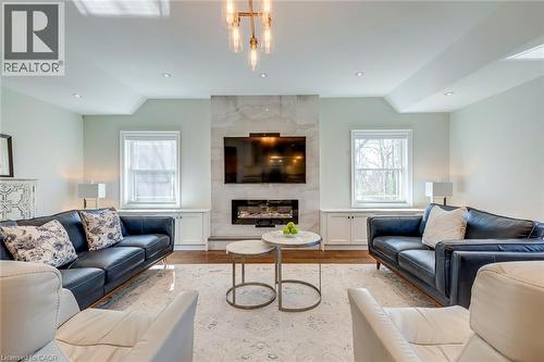 Living room featuring a high end fireplace, wood finished floors, and vaulted ceiling - 4306 Lakeshore Road, Burlington, ON - Indoor Photo Showing Living Room With Fireplace