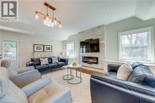 Living area featuring a high end fireplace, recessed lighting, wood finished floors, and lofted ceiling - 4306 Lakeshore Road, Burlington, ON - Indoor Photo Showing Living Room With Fireplace