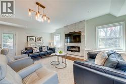 Living area featuring a high end fireplace, recessed lighting, wood finished floors, and lofted ceiling - 