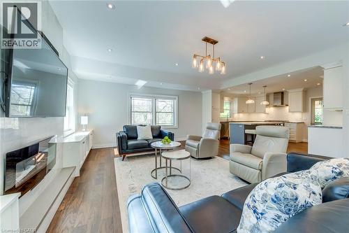 Living room featuring wood finished floors, a fireplace, baseboards, ornate columns, and recessed lighting - 4306 Lakeshore Road, Burlington, ON - Indoor Photo Showing Living Room With Fireplace