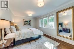 Bedroom with baseboards, ornamental molding, wood finished floors, and visible vents - 