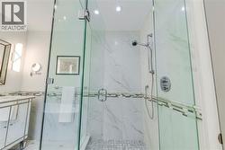 Bathroom with vanity, recessed lighting, and a marble finish shower - 