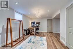 Home office with visible vents, wood finished floors, baseboards, recessed lighting, and a chandelier - 