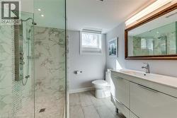 Full bath with visible vents, vanity, toilet, baseboards, and a marble finish shower - 