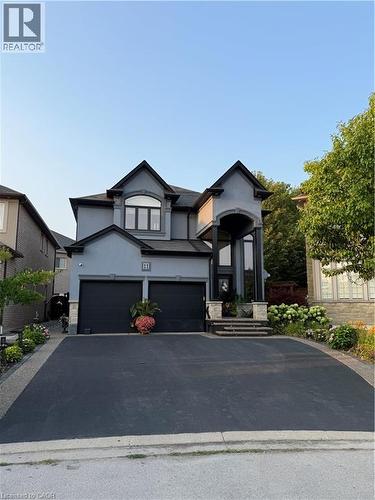 View of front of property with stucco siding, driveway, an attached garage, and stone siding - 11 Donatello Court, Hamilton, ON - Outdoor With Facade